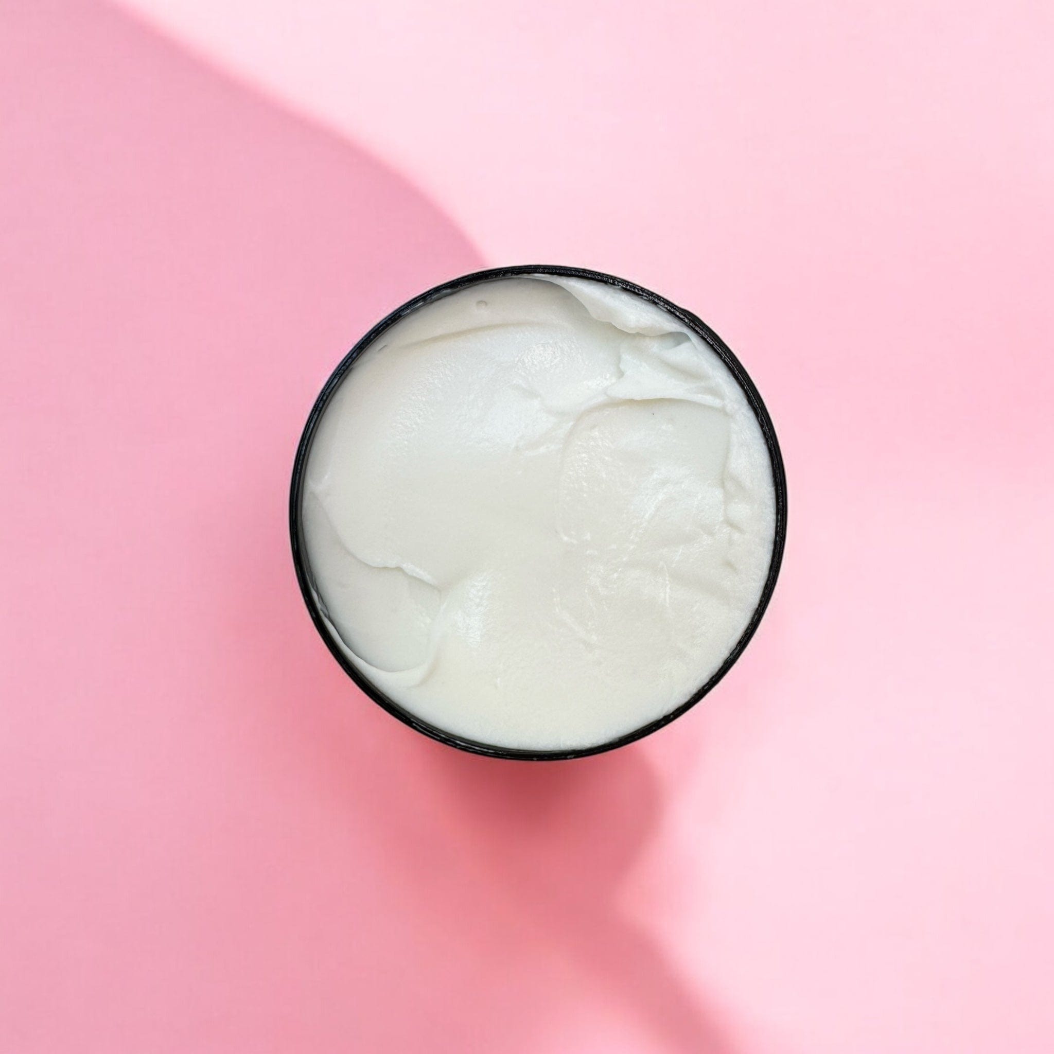 Open container of creamy white Rosewood Hand Cream with natural skincare and botanical ingredients from Puremess, set on. - Rosewood Hand Cream - PUREMESS SKINCARE