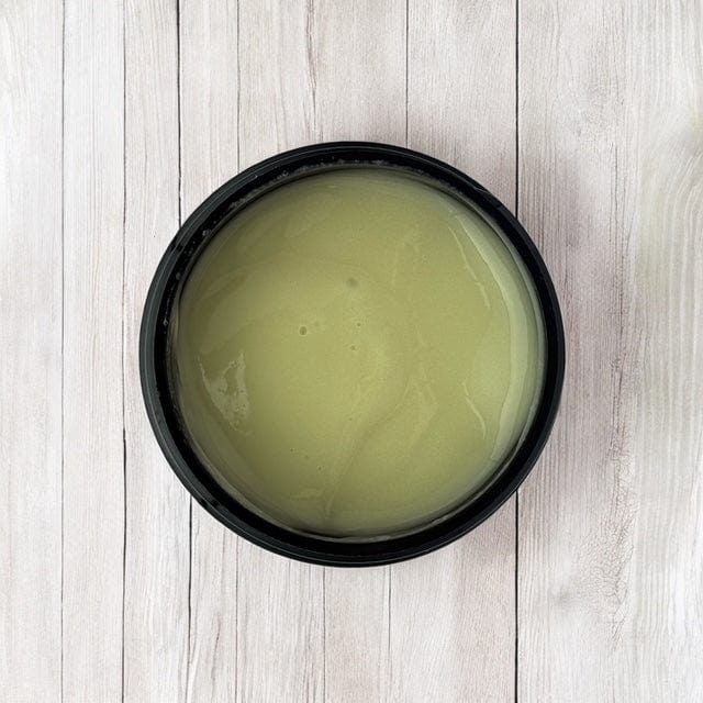 Open black container with pale green men's revitalising face cream, showcasing natural skincare with botanical ingredients. - Men's Revitalising Face Cream - PUREMESS SKINCARE