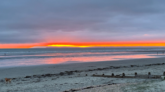 Sunset over a West Sussex beach illustrating ocean health and sustainable plant-based skincare from Puremess.