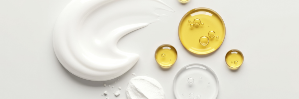 dollops of face cream and golden oil for skincare