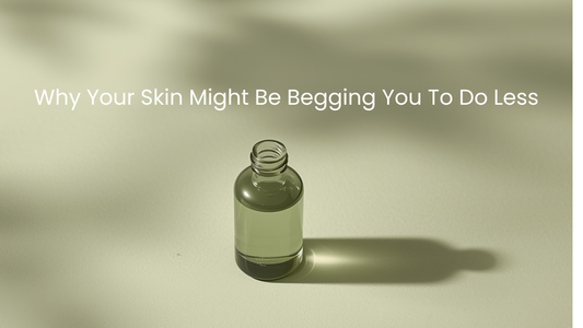 A single minimalist glass skincare bottle casting a long shadow on a soft sage green surface, with the words "Why Your Skin Might Be Begging You To Do Less" in white text.