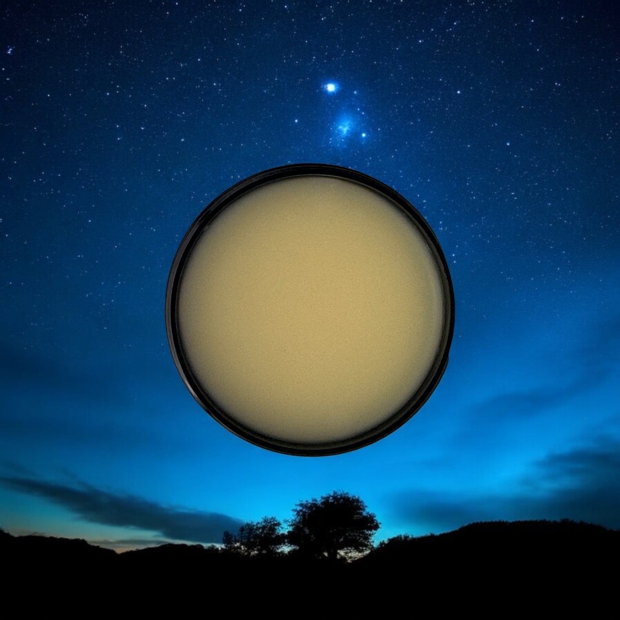 Open container of pale yellow sleep balm with smooth surface against a night sky backdrop highlighting natural skincare,. - Sleep Balm - PUREMESS SKINCARE
